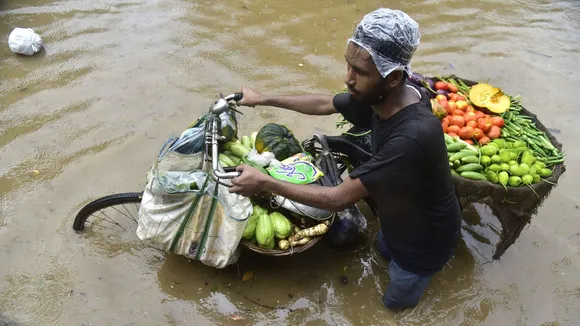 A vegetable vendor wades through a water logged street after heavy rainfall at Anil Nagar, in Guwahati, Sunday, Sept. 1, 2024.