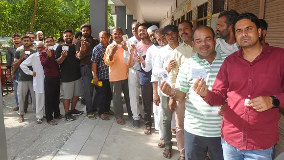 Voters wait in a queue to cast their votes at a polling station during the Haryana Assembly elections, in Sonipat, Saturday, Oct. 5, 2024