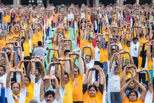 People perform yoga asanas during a yoga programme, for rehearsal ahead of the International Day of Yoga, at Mysore Palace