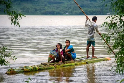 Villagers use a makeshift boat to move to a safer place from a flood-affected area following heavy rainfall 