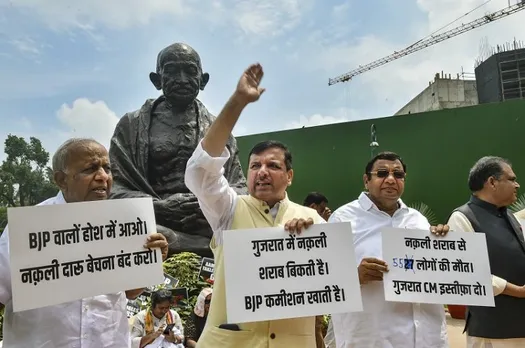 AAP MPs stage a protest over Gujarat hooch tragedy near the Gandhi statue during the ongoing Monsoon Session of Parliament, in New Delhi, Wednesday