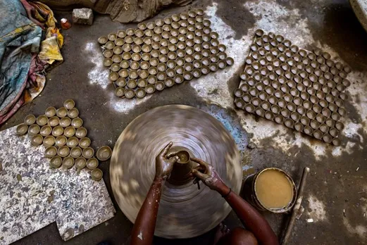 A potter moulds an earthen lamp (diya) on a wheel, ahead of the Diwali festival