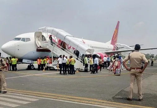 Passengers come out of the Delhi-bound SpiceJet airplane following its emergency landing after it caught fire mid-air, at Jai Prakash Narayan airport, in Patna