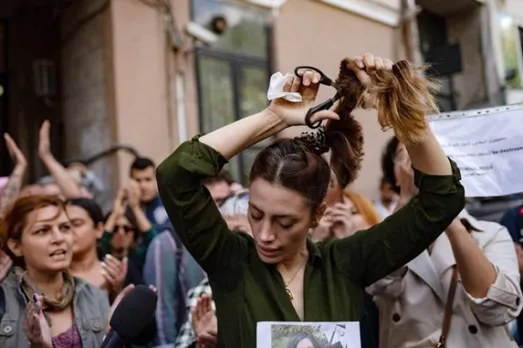 Iranian woman cutting her hair in protest