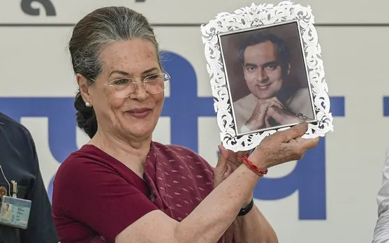 Sonia Gandhi showing a portrait of Rajiv Gandhi presented to her by Mallikarjun Kharge at AICC Headquarters on Wednesday