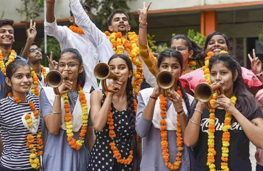 Students celebrate their success after the UP Board declared its 10th class results, in Prayagraj