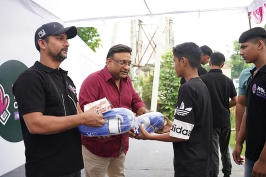 WBC Cares India team and children at Jind, Haryana, holding sports kits and smiling after the event.