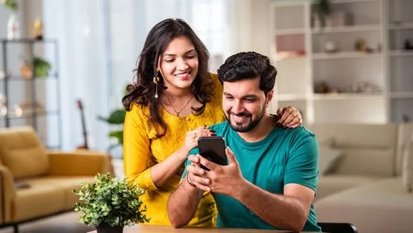 Indian family reviewing top-up health insurance plans on a laptop, with policy documents and calculator