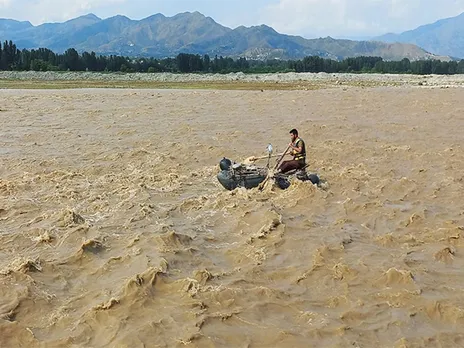 A rescue worker navigates a raft in search of survivors in Swat on June 27 (Source: Reuters)
