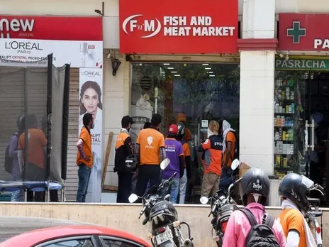 Delivery boys waiting outside store to pick their orders (Photo/ANI)