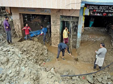 Shopkeepers remove the debris after a cloudburst, at Thunag in Mandi (Photo/ANI)