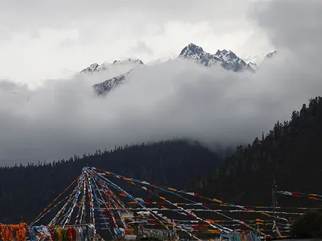 Peak of the Konpo Lhastan mountain and Tibetan prayer flags are pictured at Gaoshang Pasture Scenic Area, Tibet (Image/Reuters)