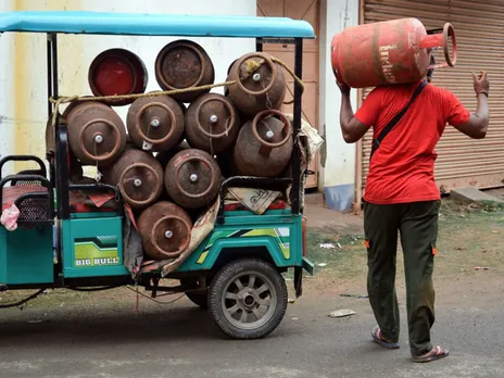 A worker carries LPG gas cylinders for delivery (File Photo/ANI)