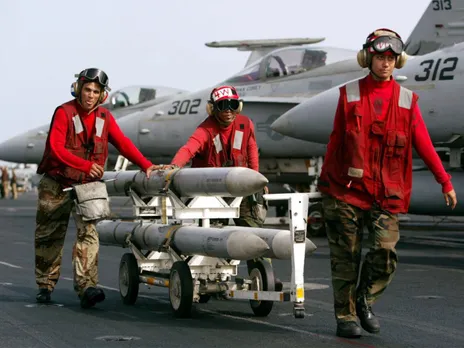 AIM-120 AMRAAM air-to-air intercept missiles are wheeled past fighter jets on the deck of the USS Kitty Hawk (File Photo/ Reuters)
