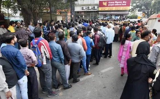 Civilians assisting police in managing long queues outside banks and ATMs in Delhi