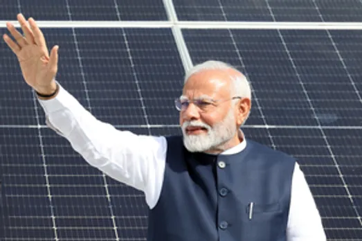 Gandhinagar: PM Narendra Modi waves to the people as he visits the residence of the beneficiaries