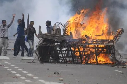 Protesters set fire during a clash with police at Dhaka University in Dhaka