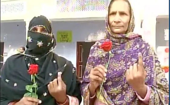 यूपी चुनाव 2017: बागपत में वोट देने आई महिलाओं का गुलाब देकर हुआ स्वागत