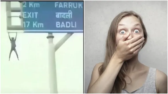 Man Hanging In Highway Signal Board