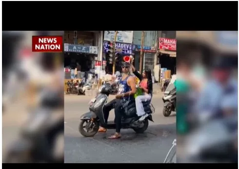 VIDEO: गर्मी से बेहाल कपल बीच सड़क चलती स्कूटी पर नहाने लगे, जानें फिर क्या हुआ
