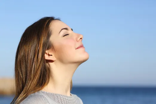 woman-breathing-deeply-beside-ocean