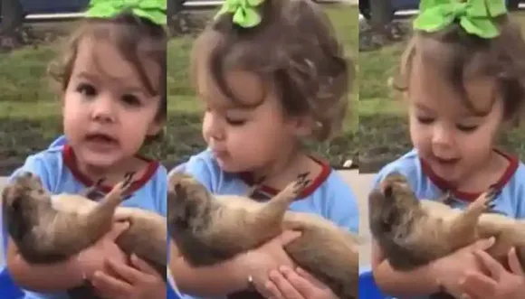 നായ്ക്കുട്ടിയെ ഓമനിച്ചുകൊണ്ട് പാട്ടുപാടുന്ന കുട്ടി; വീഡിയോ