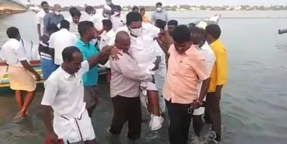 ചെരിപ്പ് നനയാതിരിക്കാന്‍ മത്സ്യത്തൊഴിലാളികളുടെ ചുമലിലേറി തമിഴ്‌നാട് ഫിഷറീസ് മന്ത്രി; വീഡിയോ വൈറലായതിന് പിന്നാലെ വിവാദം; ഫിഷറീസ് മന്ത്രിക്ക് മത്സ്യത്തൊഴിലാളിയുടെ ചുമലിലല്ലാതെ വേറെ ആരുടെ ചുമലിലാണ് കയറാനാവുകയെന്ന് മന്ത്രി