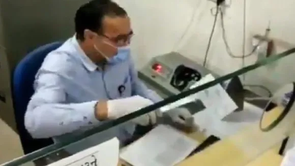 ബാങ്കിലെത്തുന്നവര്‍ നല്‍കുന്ന ചെക്ക് ഗ്ലൗസ് ധരിച്ച കൈകൊണ്ട് പോലും തൊടാതെ തോണ്ടിയെടുത്ത് അണുവിമുക്തനാക്കുന്ന ഉദ്യോഗസ്ഥന്‍ ;  ചെക്കിലെ അണുക്കള്‍ നശിച്ചാലും ഇല്ലെങ്കിലും ബുദ്ധി അപാരം തന്നെ..!!