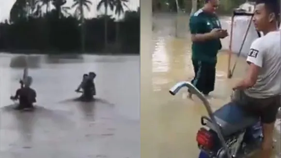 കഴുത്തോളം വെളളം, ഹാന്‍ഡിലും മറഞ്ഞ് ഒഴുക്ക്; വെളളപ്പൊക്കത്തിലൂടെ ബൈക്ക് ഓടിച്ച് യുവാക്കള്‍