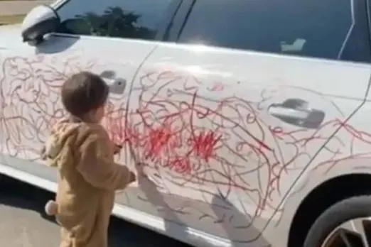 Boy Scribbles On Car