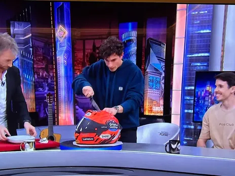 Marc Marquez cuts a helmet shaped birthday cake brought by his brother Alex Marquez
