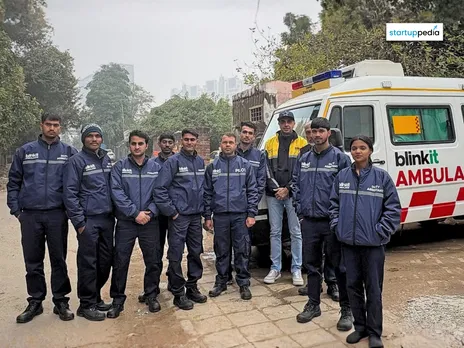 A group of Blinkit ambulance staff standing together in uniform beside a Blinkit-branded ambulance outdoors