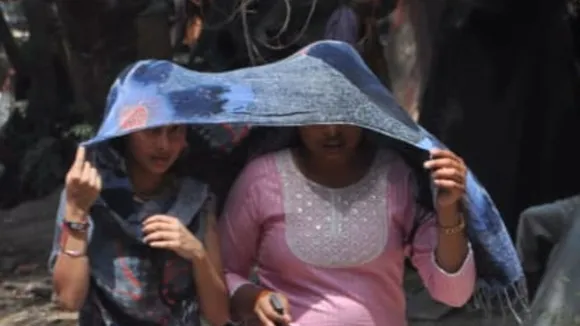 तेज धूप में अपना बचाव करती युवतियां 