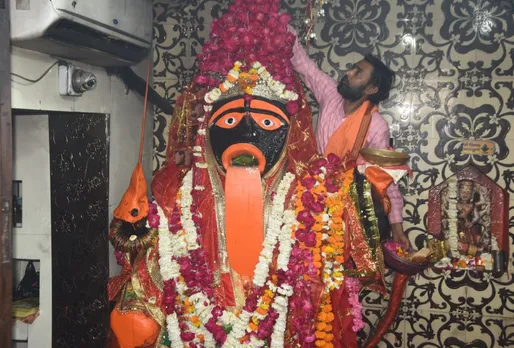 मां सतोषी की मूर्ति पर मंदिर के पुजारी जी फूल चढ़ाते हुए,