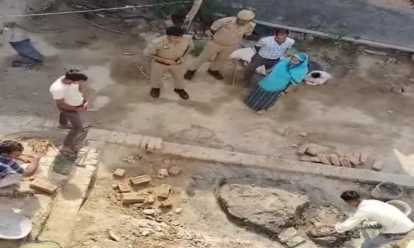 विवादित भूमि पर दीवार खड़ी करते आरोंपी
