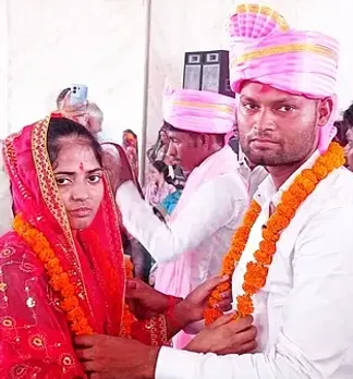 मुख्यमंत्री सामुहिक विवाह कार्यक्रम में वर को माला पहनाती वधू।