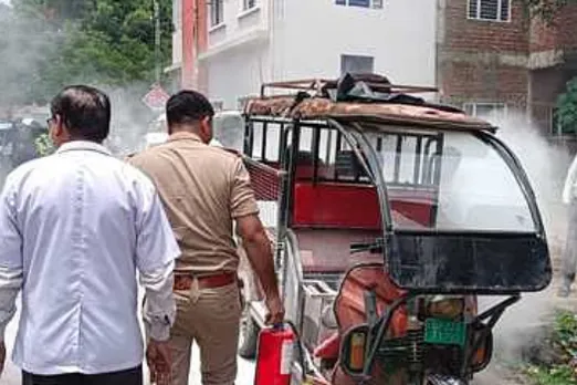 सिंजई में ई-रिक्शे में लगी आग को बुझाते दमकल कर्मी।