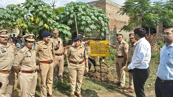 गैंगस्टर एक्ट के आरोपी की संपत्ति पर कुर्की का बोर्ड लगाते पुलिस अधिकारी