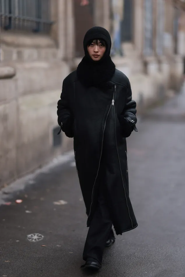 paris, france january 21: fashion week guest is seen wearing a long black coat with a large zipper, a black woolen scarf with a black knitted balaclava, black jeans and black leather shoes during the sacai show menswear fall/winter 2024/2025 as part of paris fashion week on january 21, 2024 in paris, france. (photo by jeremy moeller/getty images)