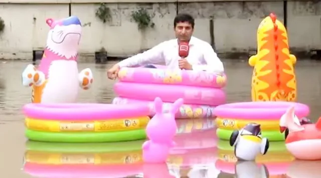 ପାଣିରେ ଭାସି ରିପୋର୍ଟ ପରିବେଷଣ କଲେ ସାମ୍ବାଦିକ ! ରାସ୍ତା ମଝିରେ ସୃଷ୍ଟି ହେଲା ସୁଇମିଂ ପୁଲର ଭ୍ରମ ।