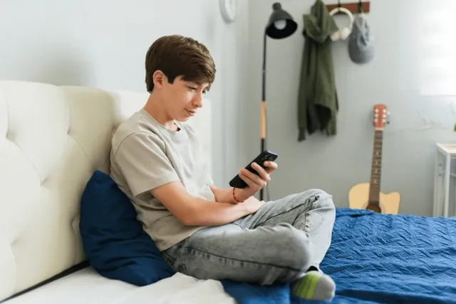 teenage-boy-using-mobile-phone-600nw-2675215599