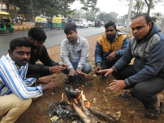 ଶୀତରୁ ରକ୍ଷା ପାଇବା ପାଇଁ ନିଆଁ ଚାରିପାର୍ଶ୍ୱରେ ବସିଛନ୍ତି ଲୋକେ। (ଫଟୋ: ବିଭୂତି, ଭୁବନେଶ୍ୱର)