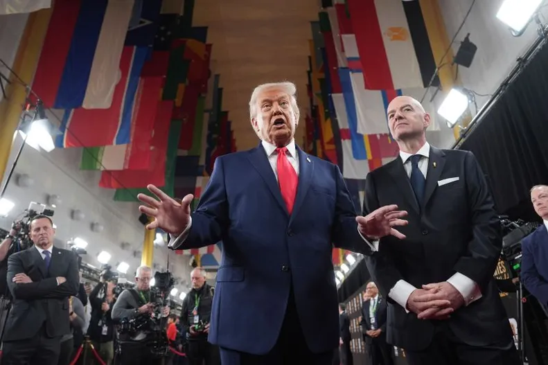 President Donald Trump speaks to members of the media during his arrival at the Kennedy Center on Friday, alongside FIFA President Gianni Infantino.