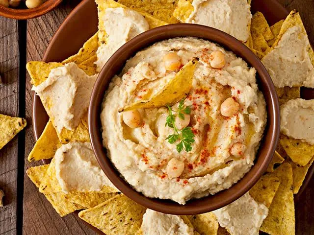 A simple recipe of Warm Hummus served with some sauteed veggies and nachos. This unique recipe is perfect for brunch, kitty parties or movie nights.