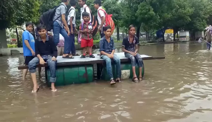 વડોદરાઃ અકોટા ગામમાં પાણી ભરાતા બેટમાં ફેરવાયું, તરાપાના સહારે શાળાના બાળકો