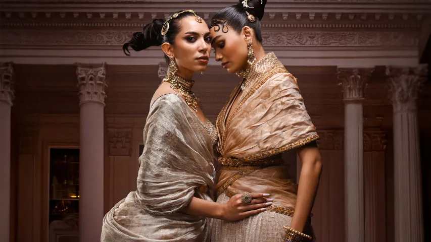 wo models in Indian couture wearing draped metallic garments emphasising sculpted hips and engineered silhouettes