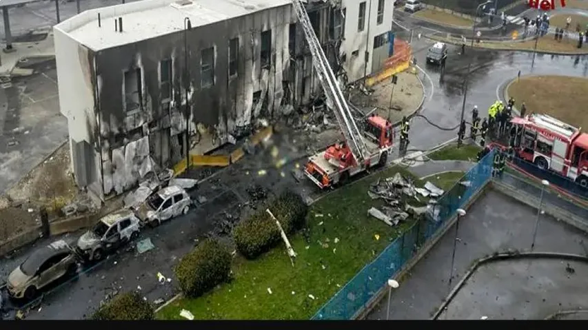 Fire fighters and police attend the scene as plane hits Milan building