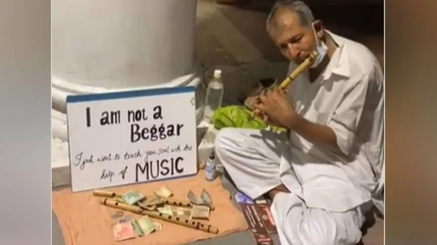 Elderly seen playing flute wrote I am not a beggar