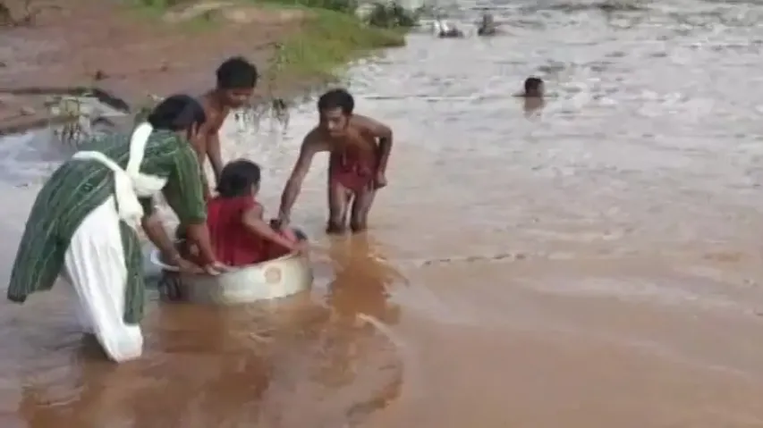 No bridge, pregnant woman crosses flooded river on cooking vessel in Koraput