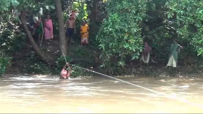 Sans bridge villagers hang on to a rope to cross river in Kandhamal
